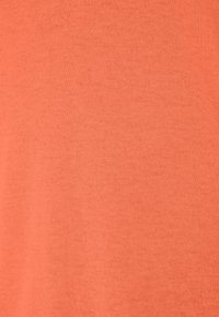 Katoenen stof in een effen, zachte perzik kleur met een gladde textuur en gelijkmatige breipatroon, geschikt voor casual kleding of om te combineren.