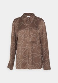 Ruskea pitkähihainen nappipaita, jossa on abstrakteja valkoisia viivamalleja ja rintatasku, esillä valkoista taustaa vasten.