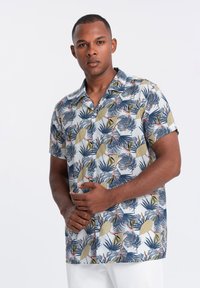 Chemise à manches courtes, boutonnée, arborant un motif de feuilles tropicales dans des tons de bleu et de vert sur un fond clair, fabriquée en tissu léger.