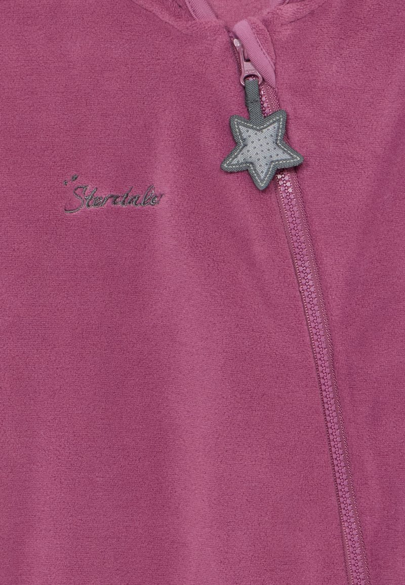 Paarse fleece kledingstuk met een rits, voorzien van een stervormige ritssluiter en geborduurd "Sterntaler" logo in zilverdraad.