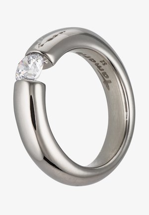 Silberner Metallring mit einem einzelnen runden, klaren Edelstein, der zwischen zwei Enden gehalten wird, mit einer Gravur innen im Ringband.