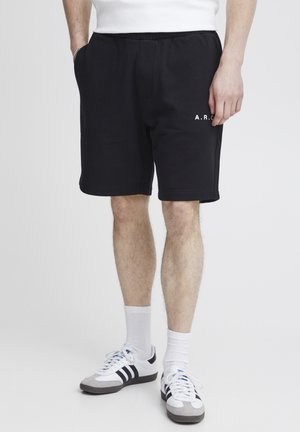 Shorts en coton noirs avec une taille élastique et des poches latérales. Avec du texte blanc "A.R.C." à l'avant. Texture lisse, design longueur genoux.