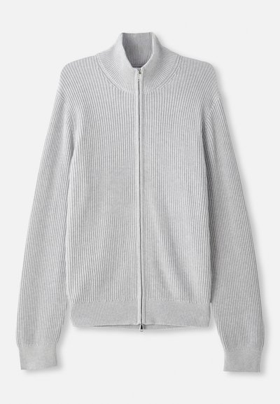 Grå ribbad tröja med hög krage och dragkedja, med långa ärmar och texturerad tyg. Enkel design och neutral färg.