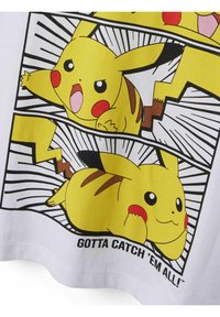 Fehér póló, melyen Pikachu illusztrációk láthatók sárga és fekete színben, a "GOTTA CATCH 'EM ALL!" felirattal, a játékos pózokkal és kifejezésekkel kiemelve.