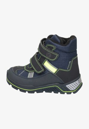 Botín oscuro de color azul marino con acentos verdes, parte superior de tela, correas de Velcro, suela de goma y detalles текстurizados, adecuado para actividades al aire libre.