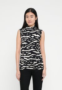 Fekete ujjatlan felső fehér zebra cs�íkos mintával, magas nyakkal és testhezálló fazonnal. Sima anyagból készült. Fekete nadrággal viselve.