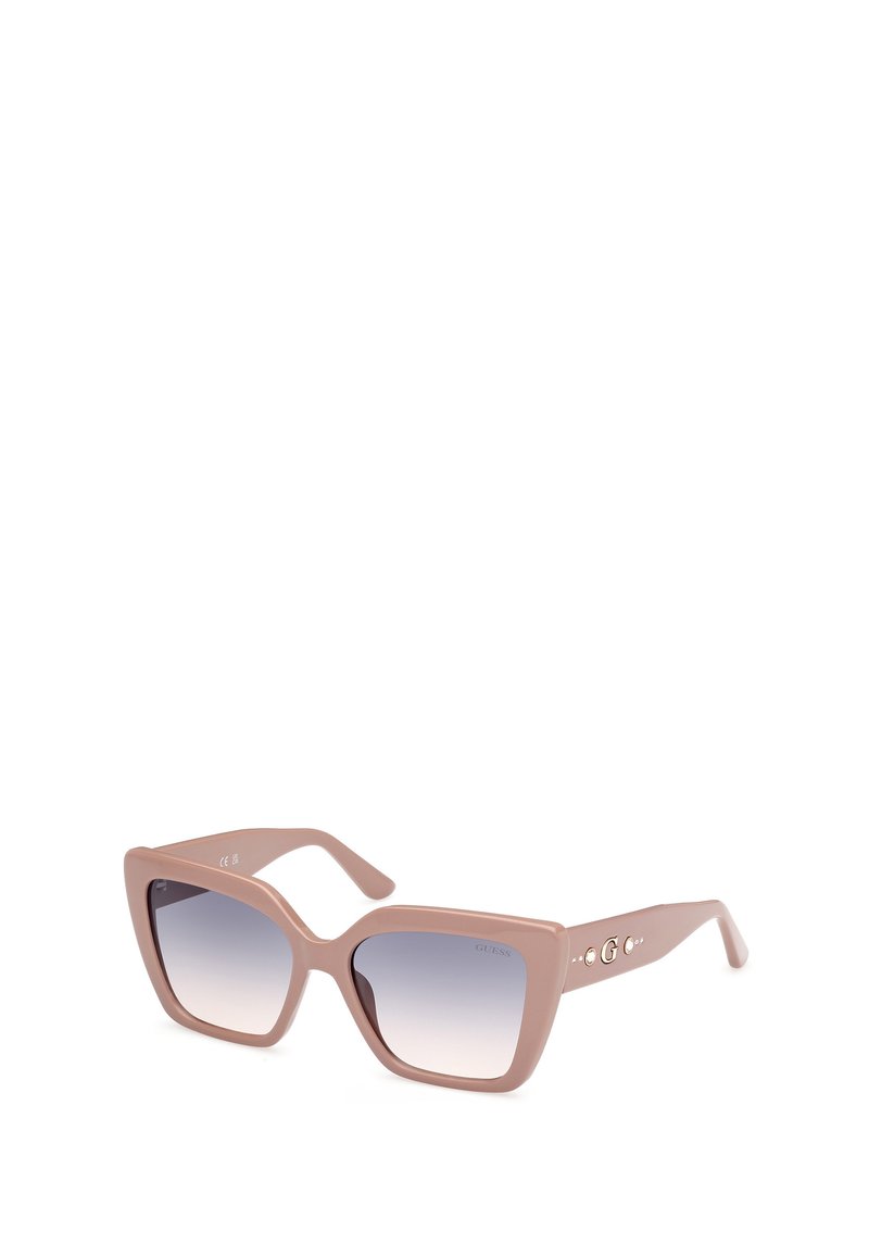 Gafas de sol de plástico rosa con montura cuadrada de gran tamaño, lentes con degradado de oscuro a claro y adornos decorativos en las patillas con pequeñas gemas.