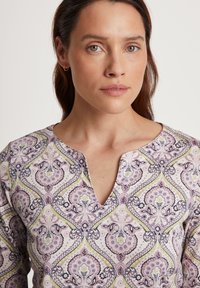 Kortebloemige top in lichtroze met een ingewikkeld paisleypatroon featuring paarse, groene en marineblauwe accenten; v-halslijn met een relaxte pasvorm.