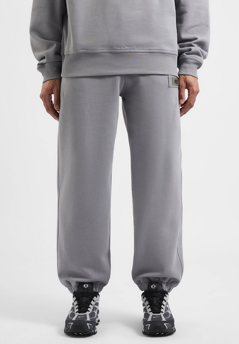Grijze sweatpants met een relaxte pasvorm, ribbelboorden en een klein logo-opdruk. Gemaakt van een zachte, gestructureerde stof met zijnaads.
