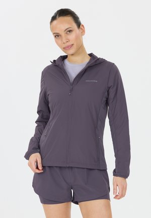 Kevyt, vettä hylkivä violetti takki, jossa on edessä vetoketju ja huppu. Takissa on slim-fit -leikkaus ja hengittävä kangas, joka on yhdistetty matchaaviin shortseihin.