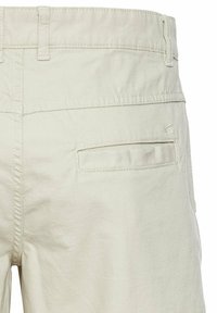 Lichtbeige katoenen broek met een gladde textuur, voorzien van een achterzak en riemlussen, ontworpen voor casual gebruik.
