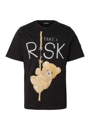 Fekete póló, amelyen egy mackó kötélre mászik, és a „TAKE A RISK” felirat látható, ahol a kötél alkotja az „I” betűt a „RISK” szóban.