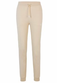 Beige Sweatpants aus weichem Material, mit einem Kordelzugbund, schmal zulaufenden Beinen, gerippten Bündchen und einem dezenten Logodetail in Hüfthöhe.