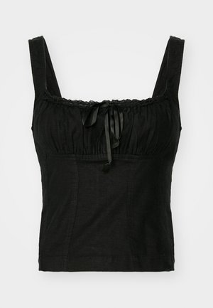 Svart cropped topp med brede stropper, samlet gjennomsiktig halslinning, sløyfedetalj og blondekant. Teksturert stoff med en kroppsnær design.