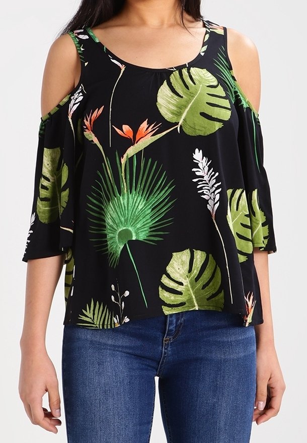 Blouse noire épaules dénudées avec imprimés de feuilles tropicales vertes et de fleurs orange, portée avec un jean en denim bleu.