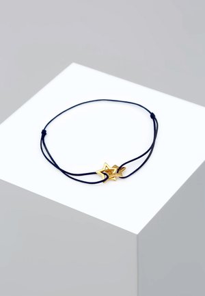 Bracelet en cordon bleu marine avec deux charms en étoile dorée brillants entrelacés, l'un légèrement plus grand que l'autre. Fermeture simple en nœud.