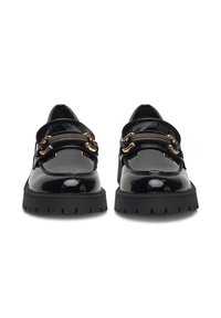 Czarne lakierowane buty skórzane z okrągłym noskiem, z dwiema złotymi łańcuchowymi paskami na wierzchu oraz teksturowaną czarną gumową podeszwą.