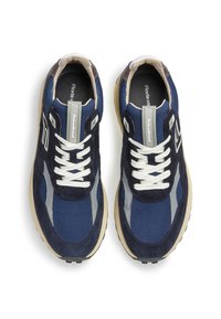 Tummansininen lenkkari, jossa on mokkasiinia ja verkkokangasta, valkoiset nauhat, heijastavat yksityiskohdat ja kermaisen värinen kumipohja. Pyöristetty kärki ja pehmustettu kaulus.