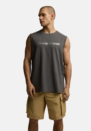 Bez rękawów, szary bawełniany t-shirt z odblaskowym logiem "diverse", w zestawie z jasnobeżowymi szortami cargo z kieszeniami po bokach.