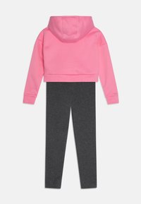 Felpa rosa corta con cappuccio e maniche lunghe abbinata a leggings grigi. Realizzata in tessuto morbido, presenta un design monocolore.