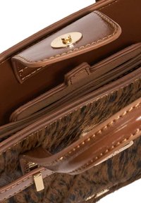 Brown handbag with a plush, fur-like texture and glossy leather accents. Features a gold snap closure and multiple interior pockets.