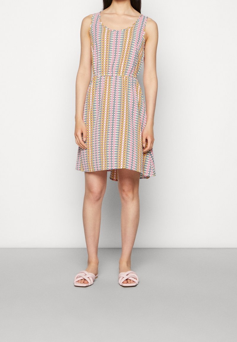 Vestido sin mangas con cintura ajustada, presenta un patrón zigzag colorido en rosa, amarillo y azul; llega por encima de la rodilla.