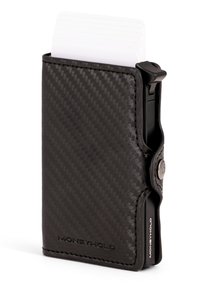 Holet ohut musta karkaistu hiilikuitulompakko, jossa valkoisia kortteja osittain ulosvedettyinä ja kylkiliike korttien käyttämiseen. Merkitty "MONEYHOLD".