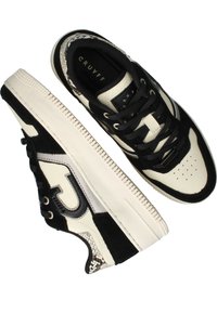 Zwarte en crèmekleurige sneaker van gestructureerd suède en leer, met een patronen hiel, ronde neus, vetersluiting en een onderscheidend logo.