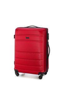 Maleta rígida roja con superficie texturizada, líneas rectas, acentos negros, dos ruedas y un asa retráctil. Logo de la marca visible.