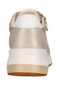 Sneaker beige clair avec des accents métalliques, capuchon de talon blanc, tissu texturé et une épaisse semelle blanche. Détail de fermeture éclair dorée à l'arrière.