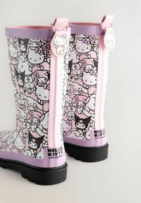 Różowe gumowe kalosze w wzór z Hello Kitty i przyjaciółmi, z fioletowym wykończeniem, metką z logo oraz teksturowaną czarną podeszwą dla lepszej przyczepności.