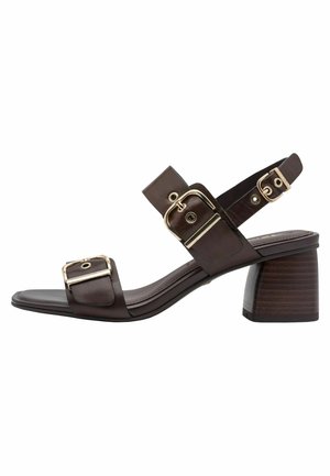 Bruine leren sandalen met hak, voorzien van twee brede bandjes, gouden hardware-accenten en een blokhak. Soepele textuur met een modern ontwerp.