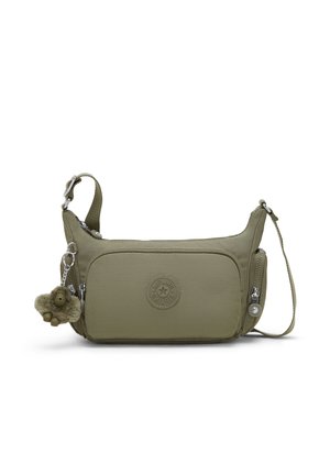 Groene crossbodytas met verstelbare riem, voorvak met ritssluiting, zijvakjes met rits en een klein pluchen apensleutelhanger eraan.