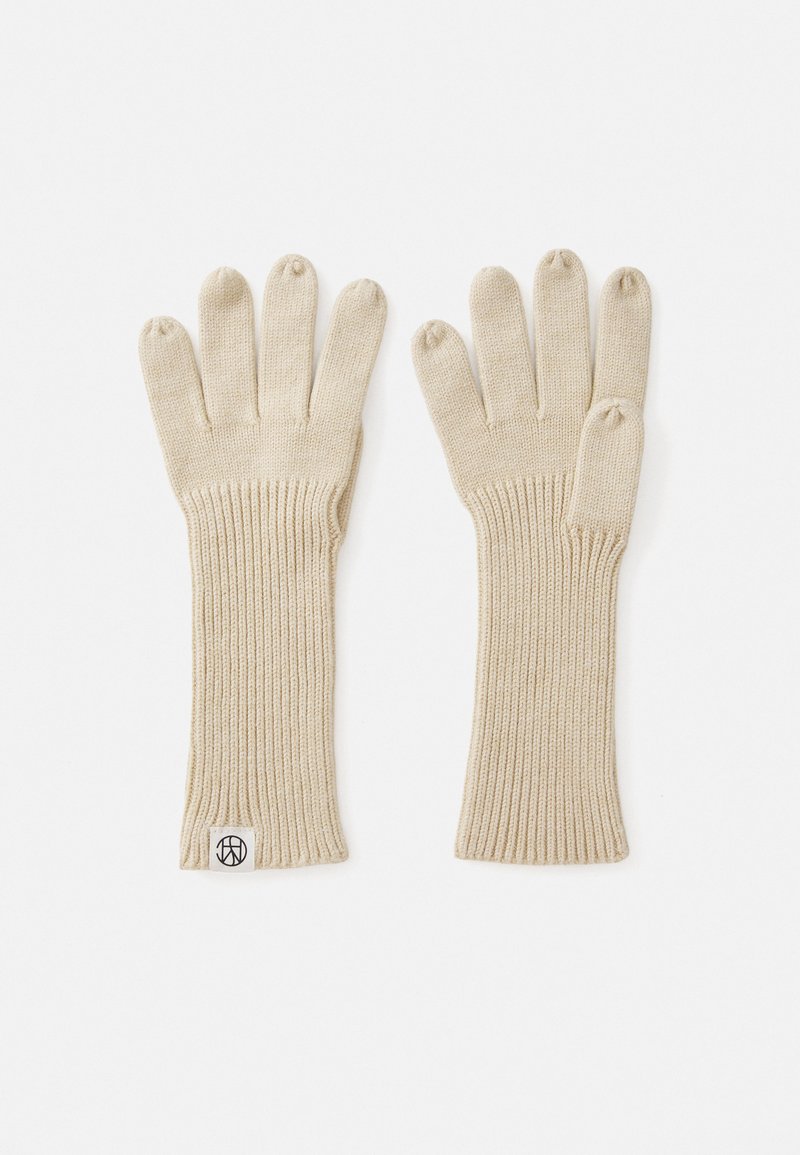 Gants en tricot beiges avec des poignets côtelés, design à cinq doigts, texture douce et une petite étiquette logo au niveau du poignet.