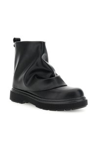 Botine negre din piele cu talpă groasă cu nervuri și un design superior plisat și șifonat, prezentate pe un fundal alb.