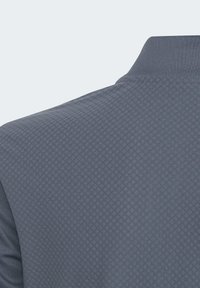 Polo grigio con un motivo a diamante testurizzato, tessuto morbido e un design classico del colletto.