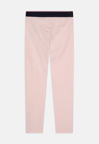 Ljusrosa leggings tillverkade av mjukt, elastiskt tyg. De har ett mörkt elastiskt midjeband och en slät yta, utan ytterligare mönster.