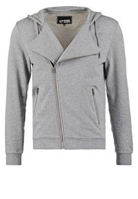 Sudadera con cremallera gris hecha de tela suave, con un elegante cuello asimétrico, bolsillos frontales y capucha con cordón.