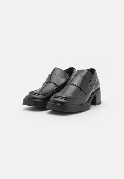 Svarta läderloafers med en tjock klack, med ett brett band över toppen, med tätstickade detaljer och en slät yta.