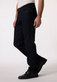 Granatowe dżinsy o prostym kroju nogawki, z przednią kieszenią, metalowym zapięciem na guzik oraz widocznymi detalami szwów.