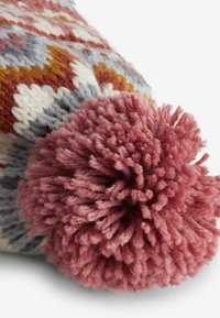 Stickad mössa med ett flerfärgat geometriskt mönster i vitt, orange, gult, grått och vinrött; prydd med en stor vinröd pom-pom.