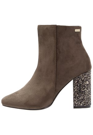 Bottine en daim marron avec un talon haut épais recouvert de paillettes noires et argentées.