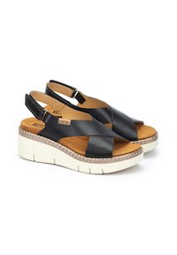 Chanclas de cuero negro con tiras entrecruzadas, plantilla acolchada marrón y suela de cuña con acentos blancos y detalles cosidos.
