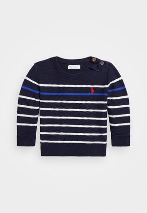 Granatowy sweter wykonany na drutach z białymi i niebieskimi poziomymi paskami, czerwonym haftowanym logo na piersi i dwoma guzikami na lewym ramieniu.