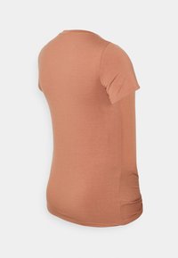 T-shirt de manga curta, com decote redondo, em tecido macio na cor laranja-rústico, com uma textura suave e bainha curva, apresentando franzidos na costura lateral.