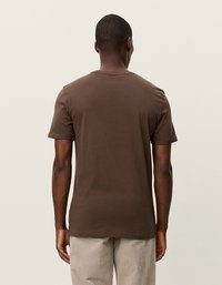Brun kortermet t-shirt lavet af bomuld, der har en klassisk pasform og rund halsudskæring. Glat tekstur med et enkelt design uden mønstre.