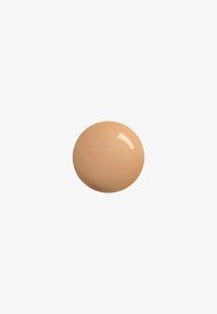 Fond de teint beige avec une texture lisse et légèrement brillante, de forme ronde et de couleur uniforme, placé sur un fond blanc uni.