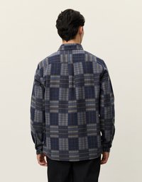 Ναυτικό μπλε καρό πουκάμισο από φανέλα με γκρι και ανοιχτό μπλε σχέδιο. Διαθέτει μακριά μανίκια, γιακά και κουμπιά στους καρπούς.