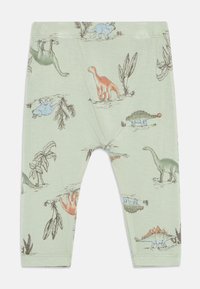 Leggings per bambini verde chiaro con illustrazioni di dinosauri e piante multicolori sparse su tutta la fantasia.