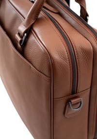 Braune Leder-Laptoptasche mit strukturierter Oberfläche, zwei Handgriffen oben, doppeltem Reißverschluss und einer Seitentasche mit Metalldetail in Ringform.